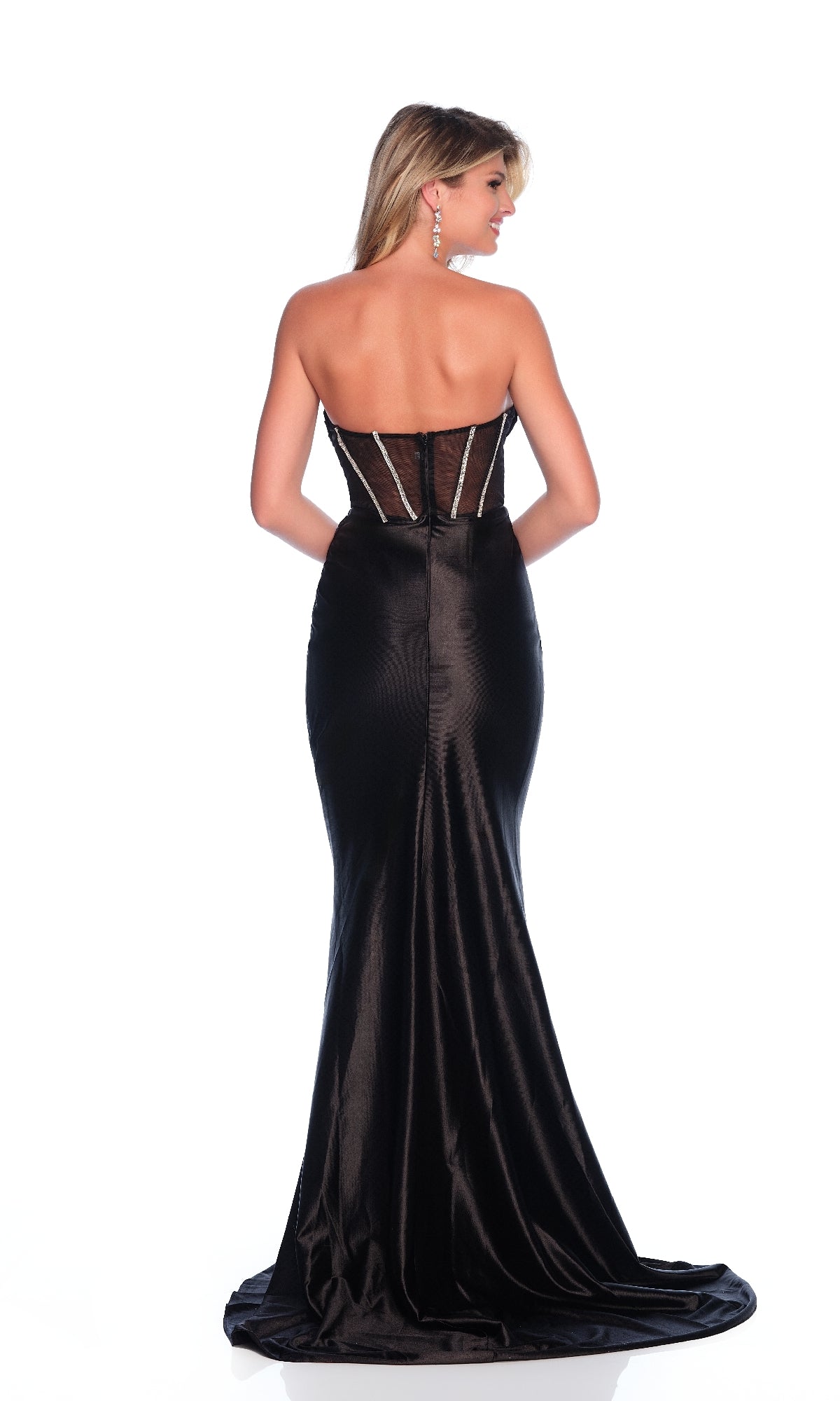 A woman models the Corset Black Prom Dress: Dave & Johnny 12310, featuring a strapless, fitted bodice with a sheer corset and slightly flared skirt, shown from the back against a white background.